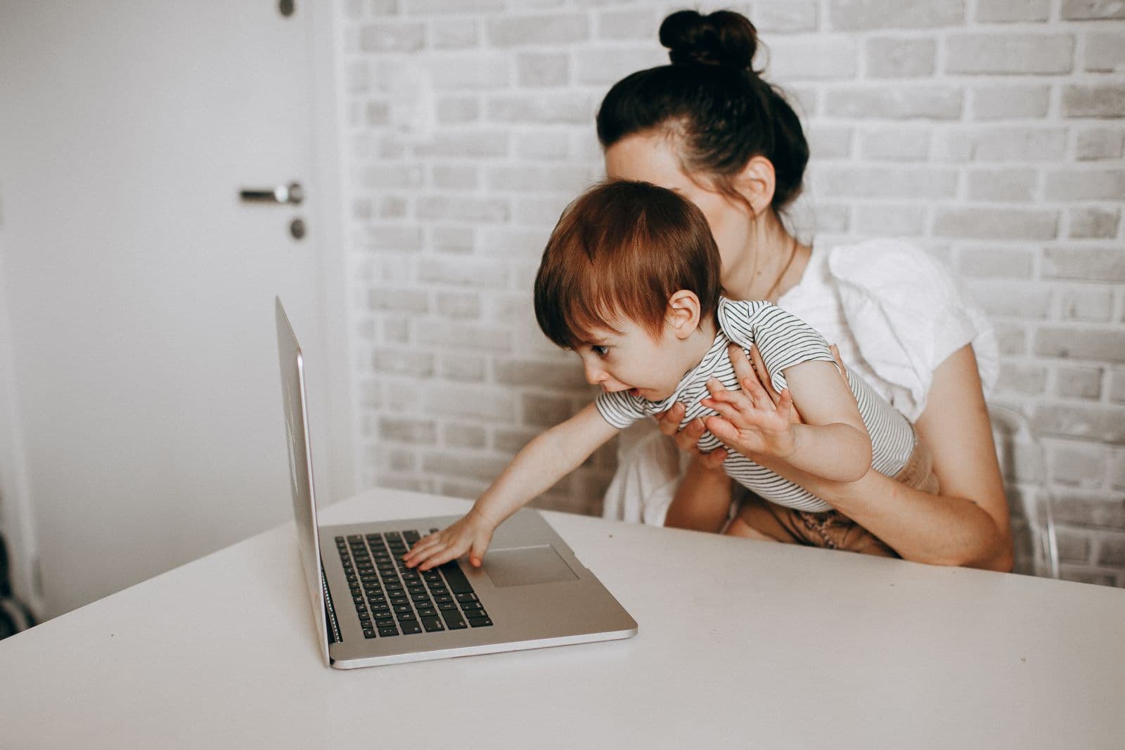 Mother and toddler looking at a laptop together at home