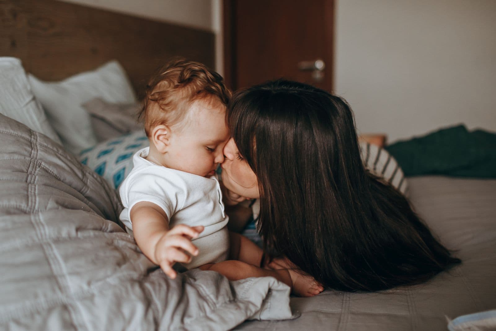 A mother tenderly kissing her baby